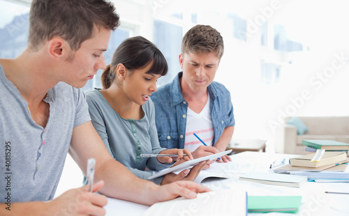 Photo: Side view of three students studying Side view of three students studying