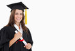 A smiling woman with a degree in hand as she looks at the camera