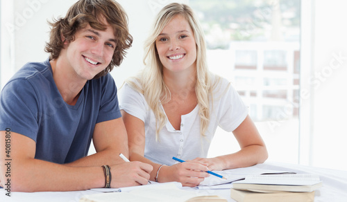 Photo: Smiling couple of students looking at the camera Smiling couple of students looking at the camera