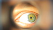 Mans eye looking through a blured hole