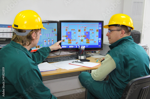 Photo: Industrial workers in control room Industrial workers in control room