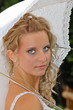beautiful bride portrait with umbrella in park