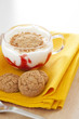 A cup of yogurt with macaroons on white background