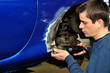 Car body worker cutting metal.
