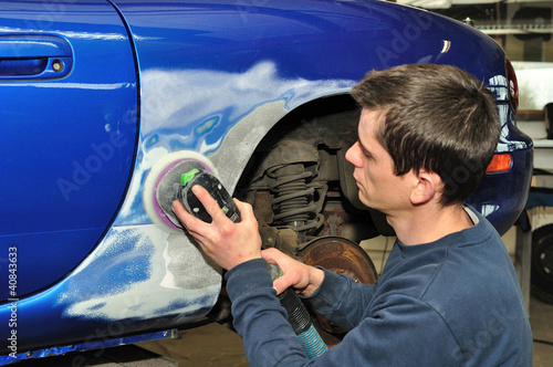 Photo: Car body worker sanding old paint.. Car body worker sanding old paint..