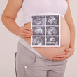 Pregnant woman holding ultrasound image Pregnant woman holding ultrasound image