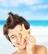 canvas print picture - Happy face boy with starfish on the beach