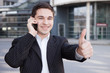 Manager mit Handy hält Daumen hoch