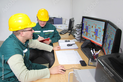 Photo: Industrial workers in control room Industrial workers in control room