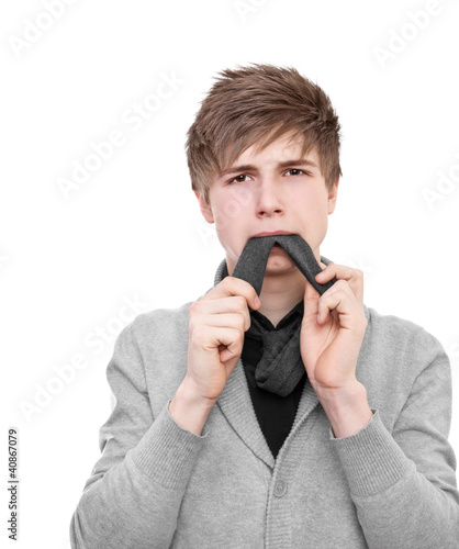 Foto: A strange young man in a gray cardigan eats his tie A strange young man in a gray cardigan eats his tie