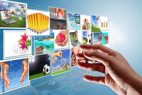 Photo: Streaming multimedia screen with reaching hand. Streaming multimedia screen with reaching hand.