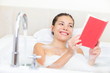 Photo: Woman reading book in bath Woman reading book in bath
