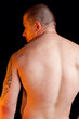 Foto: Muscular shirtless male standing with his back to the camera Muscular shirtless male standing with his back to the camera