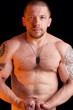 Foto: Muscular shirtless male with dog tags over black background Muscular shirtless male with dog tags over black background