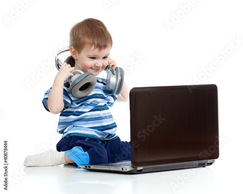 Photo: Funny child playing with laptop Funny child playing with laptop
