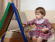 child draws on  blackboard with chalk