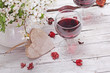 spring blossom, wine and heart  on wood background