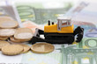 rake in heaps of money: tractor pushing heap of coins