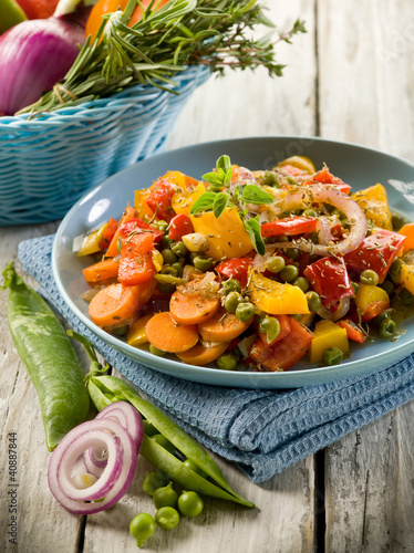 Photo: mixed sauteed vegetables on dish over wood background mixed sauteed vegetables on dish over wood background