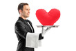 Photo: A portrait of a waiter holding a tray with a red heart shape on A portrait of a waiter holding a tray with a red heart shape on