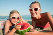 Happy summer - girls eating watermelon on the beach