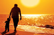 Dad and child on the beach at at sunset