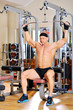 Young bodybuilder training in the gym. Back muscles, front wiew