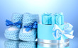 beautiful gifts and baby's bootees on blue background