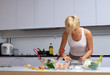 pretty blond girl in the kitchen making pasta