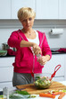 young lady making salad in kitchen