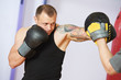 Foto: boxer man at boxing training with punch mitts boxer man at boxing training with punch mitts