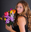 Photo: Young, beautiful woman with a colorful bouquet of spring flowers Young, beautiful woman with a colorful bouquet of spring flowers