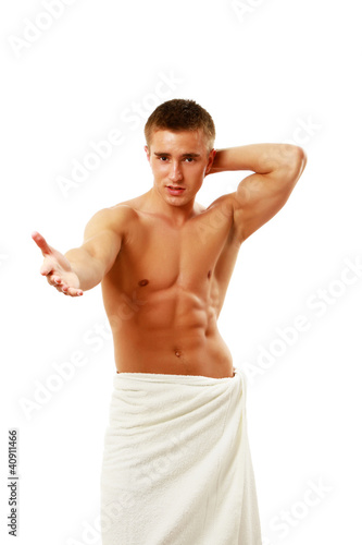 Photo: Muscle young man posing wrapped in white towel isolated Muscle young man posing wrapped in white towel isolated