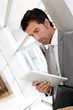 Businessman standing in hall with electronic tablet Businessman standing in hall with electronic tablet