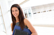 Young businesswoman in modern building holding files
