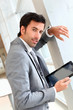 Businessman standing in hall with electronic tablet