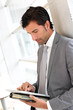 Businessman standing in hall with electronic tablet
