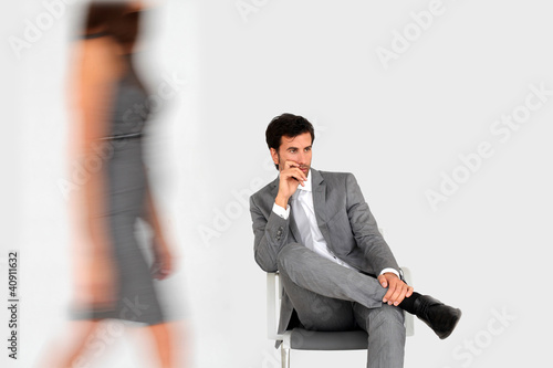 Foto: Businessman sitting in waiting room and woman walking by Businessman sitting in waiting room and woman walking by