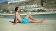Handsome man looking at sexy woman walking on the beach