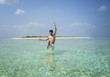 Sexy man standing in Turquoise Lagoon on the Maldives