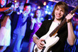 Young guitar player performing in night club
