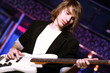 Young guitar player performing in night club