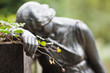träumende Frauenskulptur mit Rose in der Hand