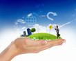 Human hand holding a green landscape