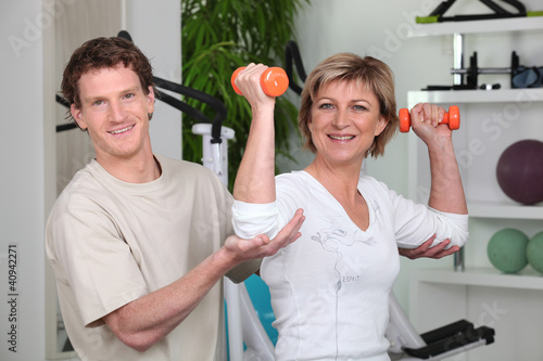 Photo: Woman being helped by her personal trainer Woman being helped by her personal trainer