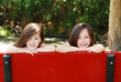 Sisters behind a Red Bench