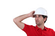 Construction worker adjusting his hard hat