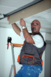 Manual worker repairing ceiling panel