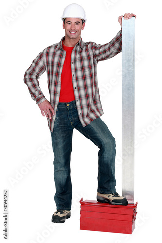 Foto: Man stood with sheet of metal Man stood with sheet of metal