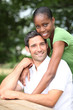 Mixed race couple sitting at a picnic table